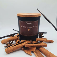 Bougie Cannelle Warmth Of Cinnamon de Calmdle be avec couvercle en bois entourée de bâtons de cannelle et anis étoilé