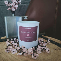 Bougie Sakura sanctuary - fleur de cerisier de Calmdle be avec fleurs roses décoratives sur une table en bois
